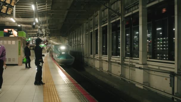 日本仙台车站日本子母弹列车 E5系列 接近月台的夜间拍摄 乘客和火车售票员在月台上等候 — 图库视频影像