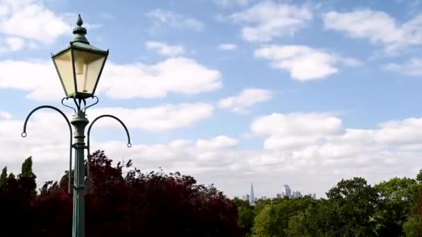 Egy régi utcai lámpa időeltolódása a Horniman Múzeumban és a londoni kertben, felhőkkel a kék égen.