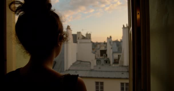 Kilátás mögött egy nő göndör haj Bun néz kívül a nyitott ablak egy békés reggel. közelről