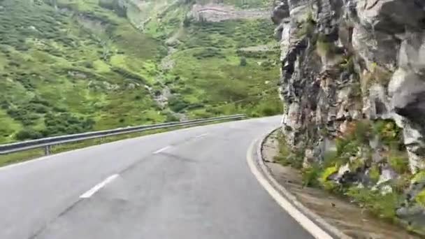 フルカ峠へのドライブ ヴァレー州のスイスにあるグリムセル峠 雨が降っていて道路はぬれている 山の中腹にパス道路上の美しい乗り心地 — ストック動画