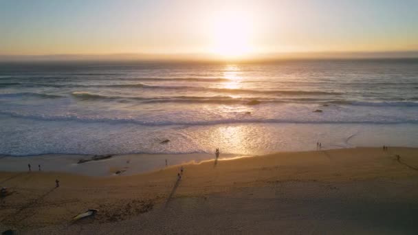 ポルトガルのギンチョビーチで日没を見ている人々の周りの空中の景色 ドローン撮影 — ストック動画