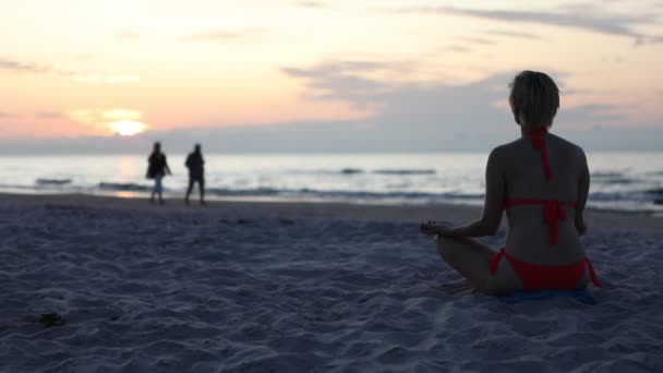 Eine Frau Sitzt Einem Roten Badeanzug Strand Und Meditiert Einen — Stockvideo