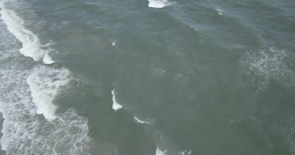 Erős tengerparti hullámok felülről lefelé, drónra néző kilátással. Ütköző hullámok az Atlanti-óceánon fehér habbal