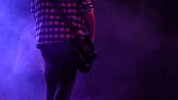 带烟熏效果和霓虹灯的乐队贝斯手在剧场舞台上演奏贝斯吉他手的剪影 后视镜 — 图库视频影像