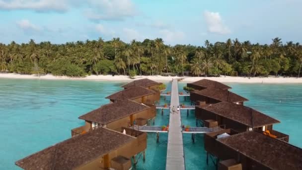 在马尔代夫梅鲁岛的一个异国情调的度假胜地 游客们沿着海滨平房走在木板路上 — 图库视频影像