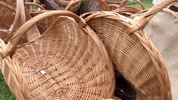 Collection of wicker baskets selling on the market. Empty wicker picnic baskets, Easter holiday containers stacked on the meadow. Collection of brown handmade rattan basket.