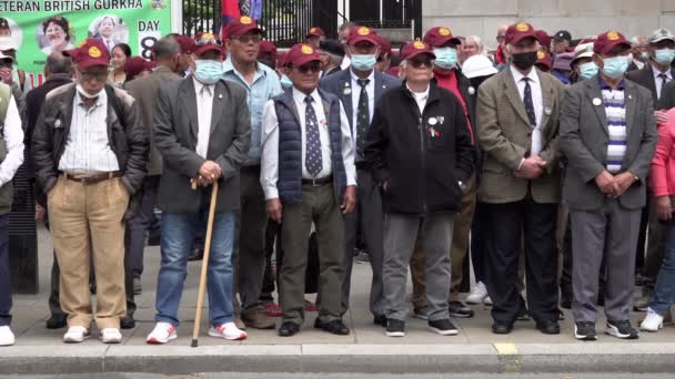 イギリスのグルカの退役軍人はダウニング街の反対側で抗議するときに月の野球帽を身に着けて一緒に立ち すべてのグルカの退役軍人のための完全な軍事年金を求める — ストック動画
