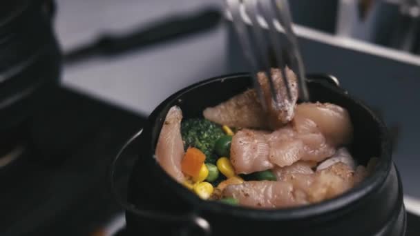 スローモーションの女性が鍋に鶏や野菜をかき混ぜて — ストック動画