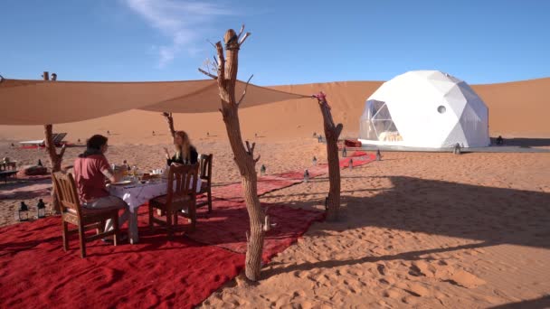 年轻夫妇在他们的穹顶帐篷附近吃午饭 豪华的撒哈拉沙漠营地 静坐射击 — 图库视频影像