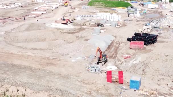 住宅開発建設現場でセメントパイプ空中ビューを準備掘削掘り車 — ストック動画