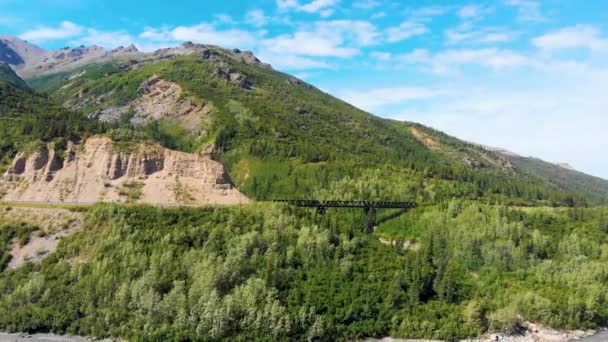 4K Drone Video of Train Trestle bridge and Mountains Rising above the Chulitna River near Denali National Park and Preserve, AK during Summer