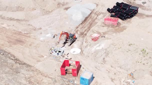 住宅開発現場でコンクリート管空中コンジットビューを準備掘削掘り車左プッシュイン — ストック動画