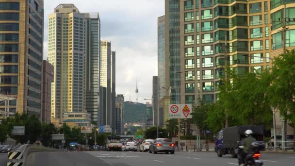 Verkeer Rijden Stad Passeren Door Hoge Gebouwen Met Namsan Tower — Stockvideo