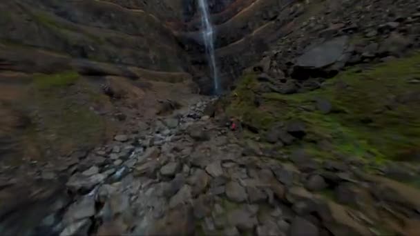 FPV drone blízkost letu nahoru vodopádem a pak potápět se vedle něj na Islandu
