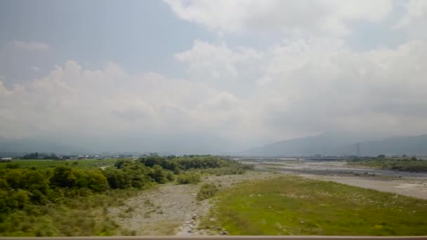 在一个多云的日子里 坐火车穿过一条宽阔的河流 从星辰窗口俯瞰日本农村 — 图库视频影像