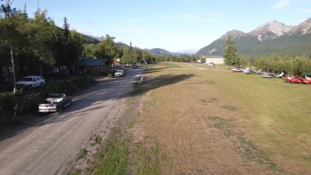 在Talkeetna山脉 无人机镜头缓慢地飞越一条私人草地跑道 车辆停放在建筑物周围 在阿拉斯加帕尔默附近的国王牧场拍摄 — 图库视频影像