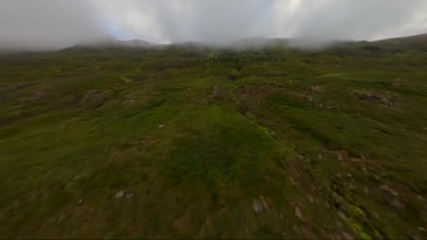 Fpvドローンが霧の雲を通ってアイスランドの山の端を飛んでいます — ストック動画