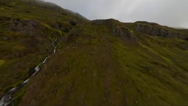Fpvドローン近くの丘の上に飛んで アイスランドの小さな山の川に続く — ストック動画