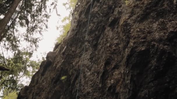 Cara Escalada Roca Con Una Cuerda Colgando Sobre Borde Acantilado — Vídeos de Stock