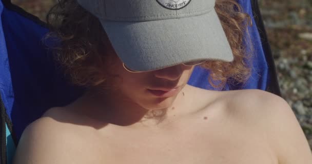 Młody Mężczyzna Bez Koszuli Czapce Relaksujący Się Pod Słońcem Plaży — Wideo stockowe