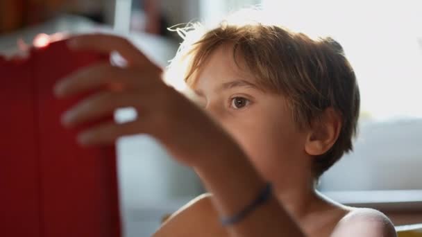 Pět let starý chlapec pomocí digitální tablet sedí na stole