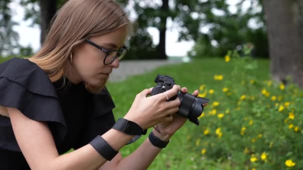 Profil mladé ženy fotograf s fotoaparátem Fotografování květin v parku Full Frame Slow Motion