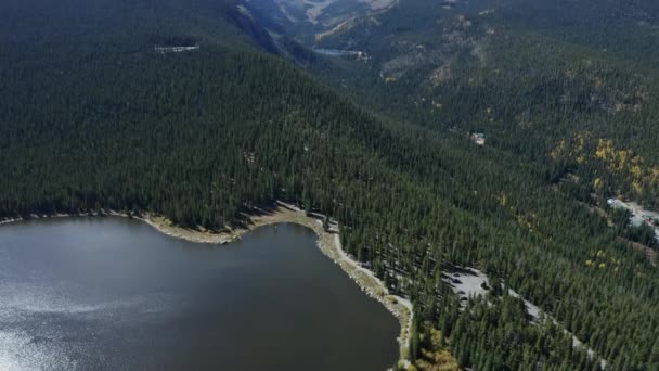 Flygfoto Panorering Upp Från Alpin Sjö Till Snöiga Berg Fjärran — Stockvideo