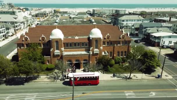 Grande Église Catholique Tournante Aérienne Avec Chariot Rouge Stationné Devant — Video