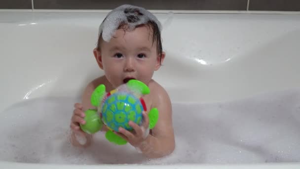 可爱的乌克兰 韩国幼儿托德勒与五彩斑斓的玩具龟在浴盆与泡沫玩耍 — 图库视频影像