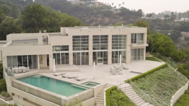 A sweeping aerial view of a modern Beverly Hills Mansion and surrounding grounds.