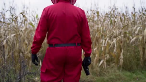 Man Holding Gun Wearing Red Squid Game Character Costume Walks — Stok Video