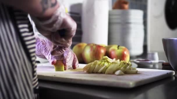 Frau Schneidet Äpfel Handschuhe Küchenvorschriften Extreme Nahaufnahme Von Der Seite — Stockvideo