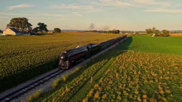 蒸気機関車と乗客のコーチによる空中からの眺め列車の前後に煙と蒸気を吹いて接近ゴールデンアワー中 — ストック動画