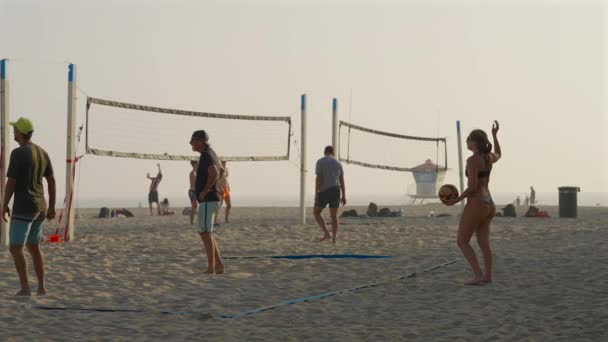 在加州亨廷顿海滩的一场沙滩排球比赛中 一个白人女孩在打排球 减速至25度 — 图库视频影像