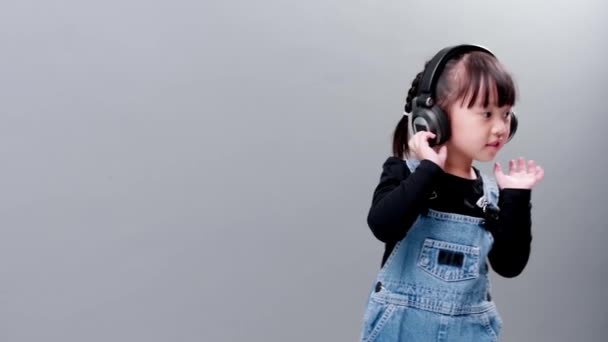 Kind Hört Musik Mit Headset Jeans Auf Grauem Hintergrund Studio — Stockvideo