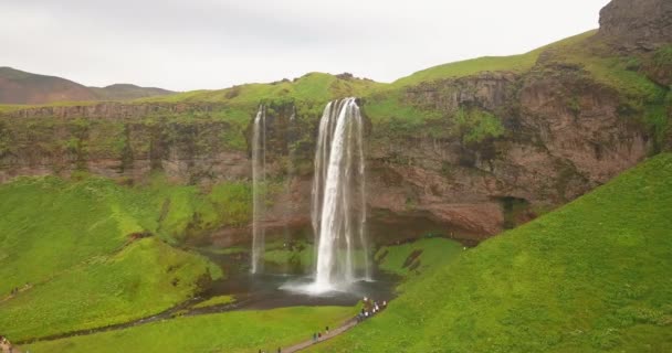 Obracający Się Dron Filmowy Ujęcia Wodospadu Islandii Ludźmi Oglądającymi Ziemi — Wideo stockowe