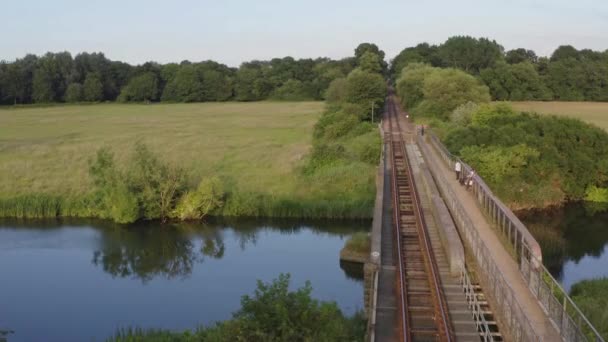 Kamera Zoomning Järnvägsspåret Korsar Ett Grönt Fält Omgivet Skog — Stockvideo