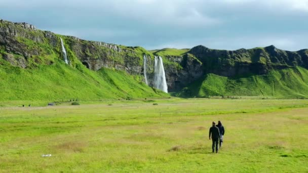Nature Photographers Walking Green Grassy Field Seljalandsfoss Iceland Inglés Ancho — Vídeos de Stock