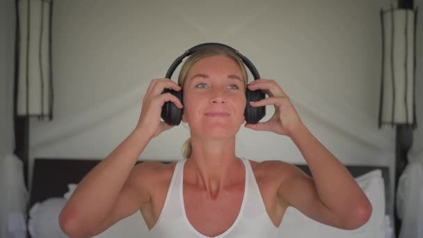 Blond Woman Puts Headphones Listen Music Swaying Head Carefree — Stock Video