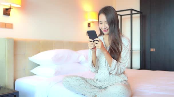 Νεαρό Όμορφο Ασιατικό Woman Στην Pajama Γραπτών Μηνυμάτων Smartphone Χαμόγελο — Αρχείο Βίντεο