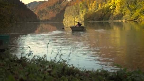 缓慢的运动 人在秋天划船在湖面上 周围是红黄的秋叶 — 图库视频影像
