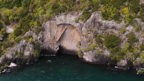 タウポ湖沿岸の岩肌に彫り込まれたマオリ族の作品 ニュージーランド人気の観光名所 航空軌道 — ストック動画