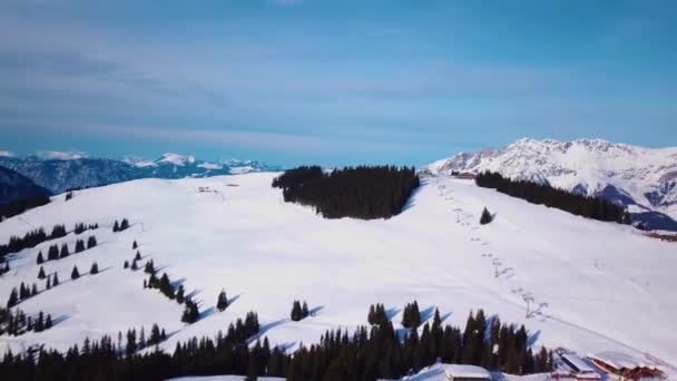 天気の良い日にスキー場 森の山のスキー場で雪 スキーリフトの駅やカフェの近くに多くの観光客 空中展望 — ストック動画