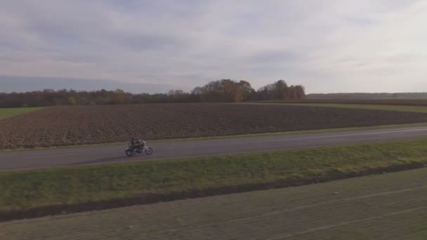 秋にオートバイに乗る男 空中追跡ショット — ストック動画