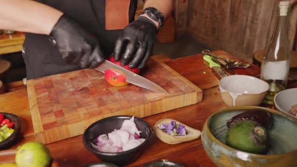 A male professional culinary chef cutting and peeling fresh mango on a chopping board, preparing ingredients for appetizer.