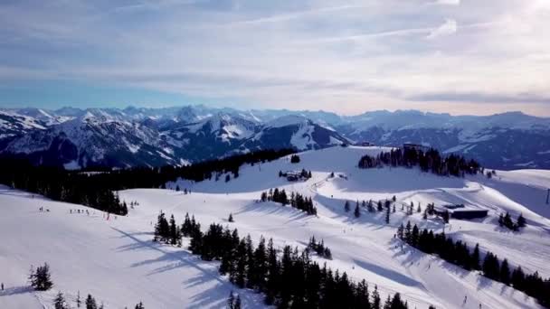 空中からの眺めスキー場のスキー場沿いの滑らかな動き 雄大な雪の山と青空 冬景色 — ストック動画