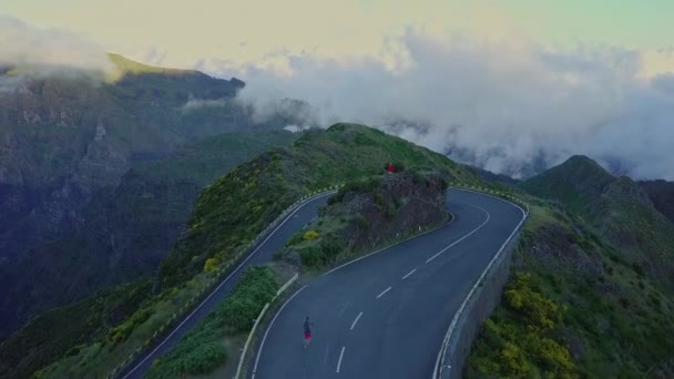美しい雲が満たさ谷の上の道路上のヘアピンターン上の空中移動 — ストック動画
