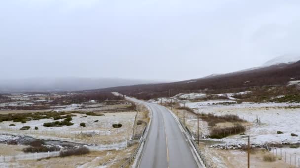 在挪威 乡间田野间的冬季公路与遥远的雾山路相望 — 图库视频影像