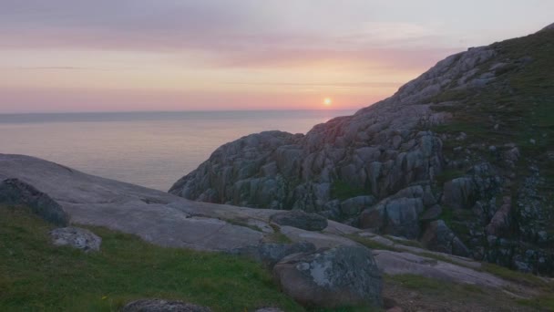 海岸線に沿って崖の上から地平線まで眺め 美しいピンクの夕日と澄んだ空で穏やかな海を見下ろす — ストック動画