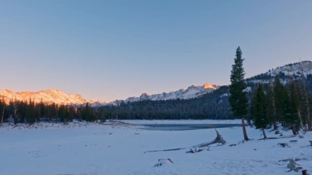 雪に覆われたマンモスの蹄鉄湖と陽射しの強い山と澄んだ夕焼け空の背景 — ストック動画